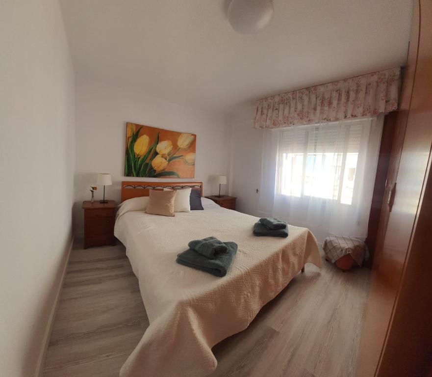 1 dormitorio con 1 cama con 2 toallas en Renovado piso céntrico en Fuengirola en Fuengirola