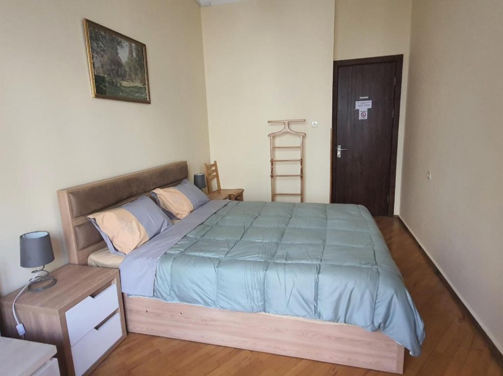 a bedroom with a bed with a blue comforter at Guesthouse Hillside in Tbilisi City