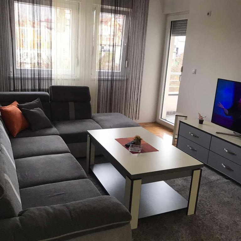 a living room with a couch and a coffee table at Apartman Jaca in Tuzla