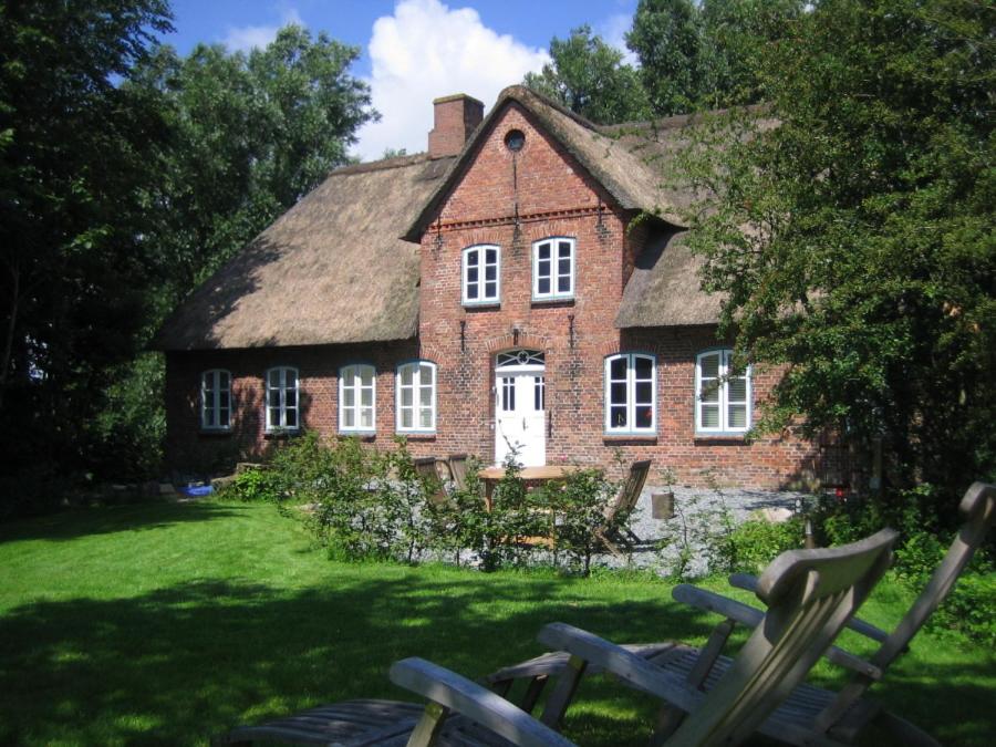 een oud bakstenen huis met een grasveld ervoor bij Casa Del Norte in Neukirchen