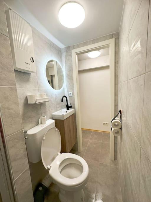 a bathroom with a toilet and a sink and a mirror at Micro Appartement hbf 7min in Duisburg