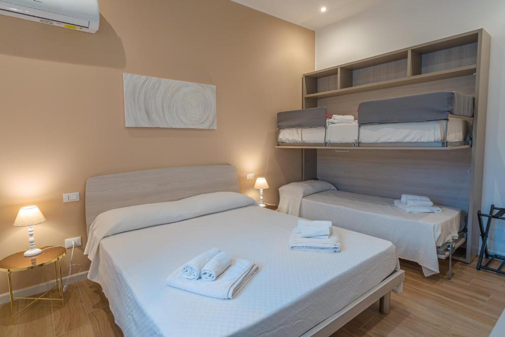 a room with two beds with towels on them at Casa Lighea Mondello - 200 mt dalla spiaggia in Mondello