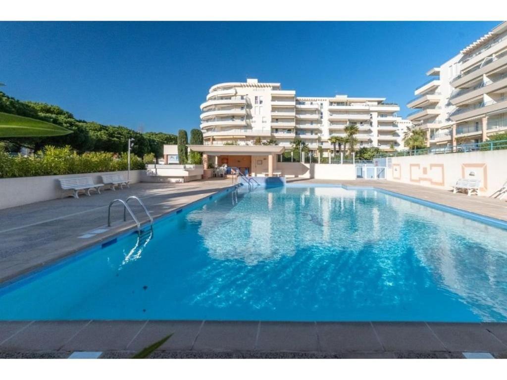 une grande piscine avec des bâtiments en arrière-plan dans l'établissement Appartement Studio Cabine à Fréjus, Piscine, Plage à 500m, Clim, Parking, Terrasse, 4 Couchages - FR-1-226A-110, à Fréjus