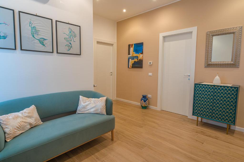 a living room with a blue couch and a mirror at Casa Lighea Mondello - 200 mt dalla spiaggia in Mondello