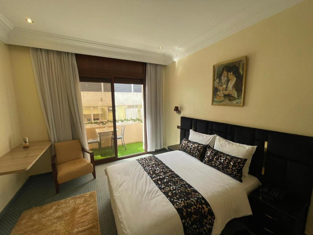 Astoria في الدار البيضاء: غرفة نوم بسرير وكرسي ونافذة