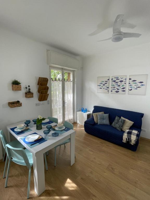 a living room with a table and a blue couch at VILLA ROMANA in Diano Marina
