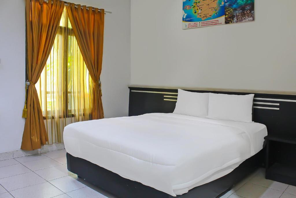 a large white bed in a room with a window at Collection O 92268 Hotel Aero in Negarasaka