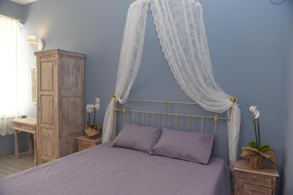 a bedroom with a purple bed with a canopy at Oisyra Boutique Suites in Ermoupoli