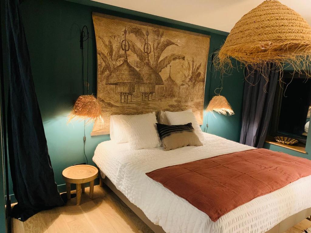 sypialnia z łóżkiem z obrazem na ścianie w obiekcie La Cambrousse 