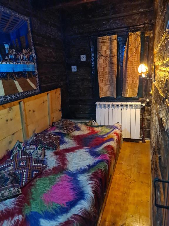 - une chambre avec un lit et une couverture colorée dans l'établissement Casa Hariton, à Drăguş