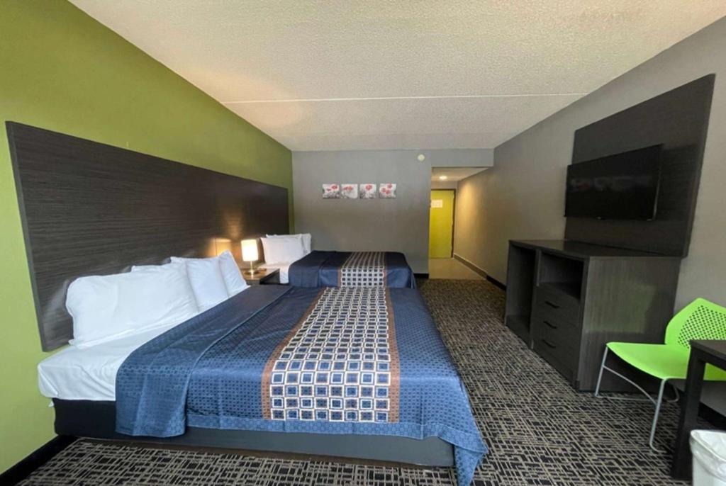 pokój hotelowy z łóżkiem i telewizorem z płaskim ekranem w obiekcie Wingate by Wyndham Lake George w mieście Lake George
