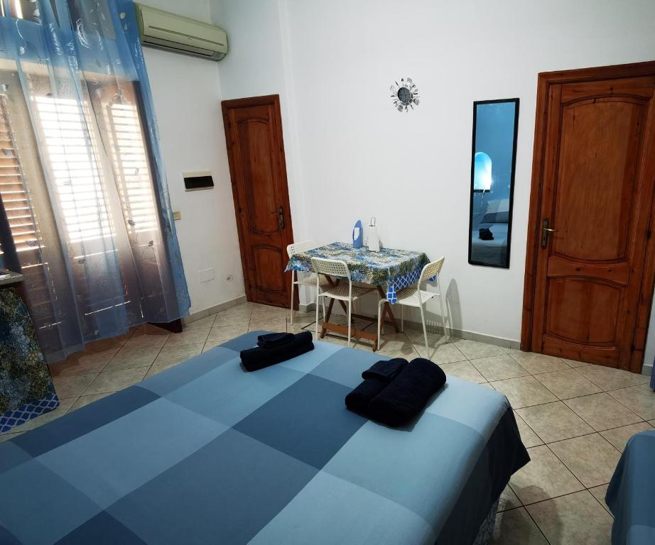 - une chambre avec un lit bleu et une table dans l'établissement Appartamento Central, à Lipari