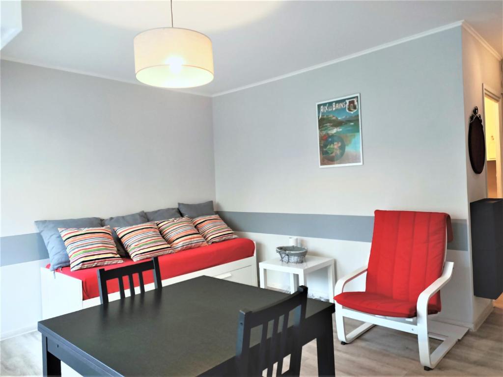 ein Wohnzimmer mit einem roten Sofa und einem Tisch in der Unterkunft Studio Aix-les-Bains, 1 pièce, 2 personnes - FR-1-555-37 in Aix-les-Bains