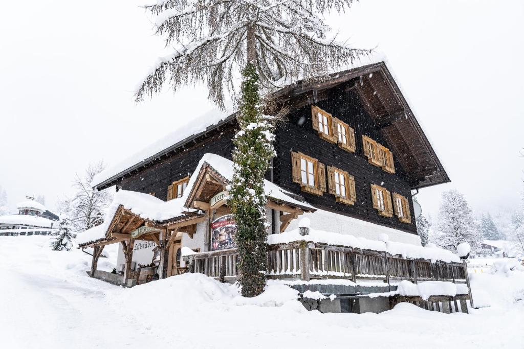 een groot houten huis met sneeuw erop bij Liftstüberl Zaglauhof in Werfenweng