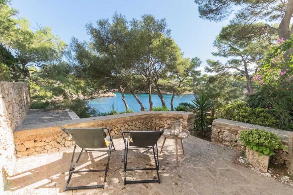 a patio with two chairs and a table and water at Apartamento Ferrera Park 103 in Cala d´Or