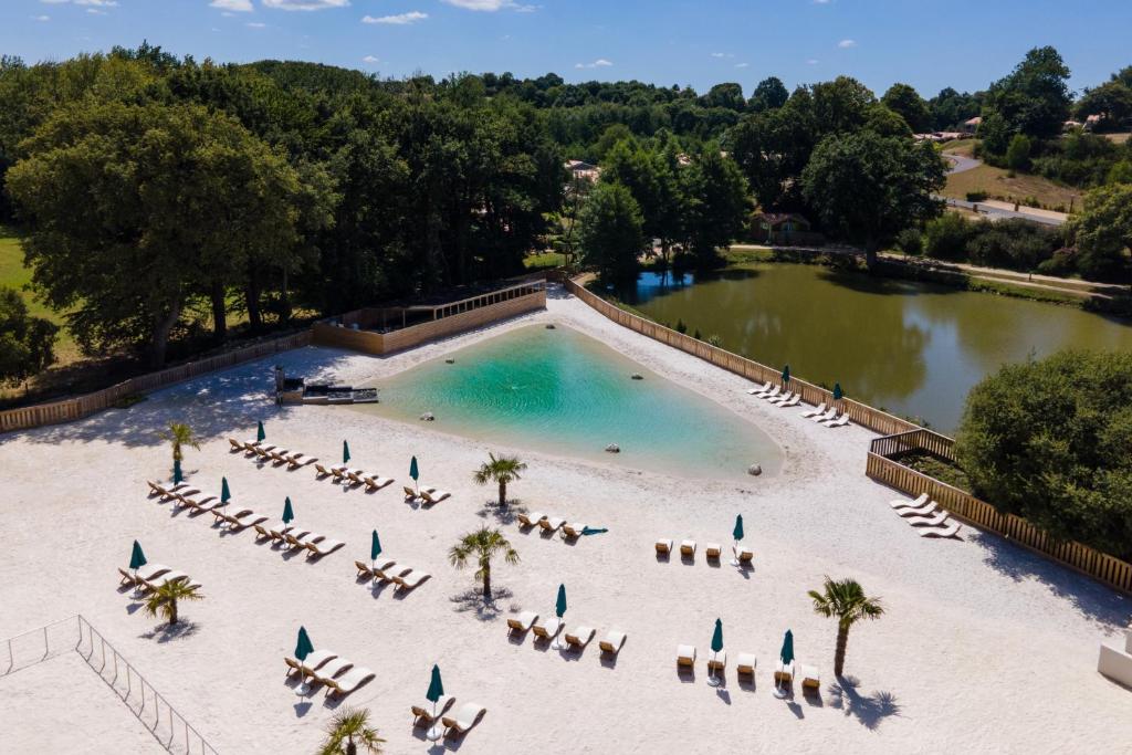 an aerial view of a pool with chairs and a beach at Domaine Mélusine - à 2km du Puy duFou ! in Les Épesses