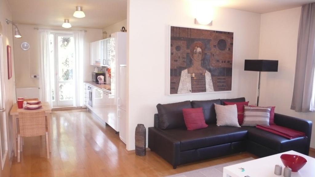 sala de estar con sofá negro y mesa en Apartment Kosatcová en Praga