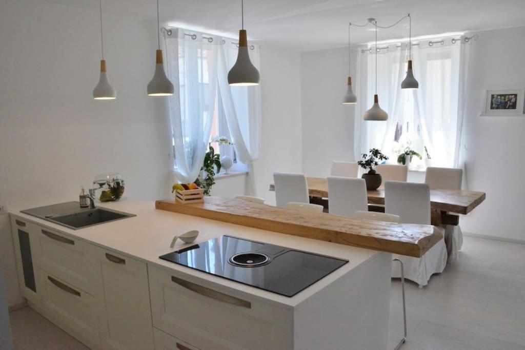 uma cozinha com um lavatório e uma mesa com cadeiras em Villa di Design con Giardino e Spa in Cittá em Cuneo
