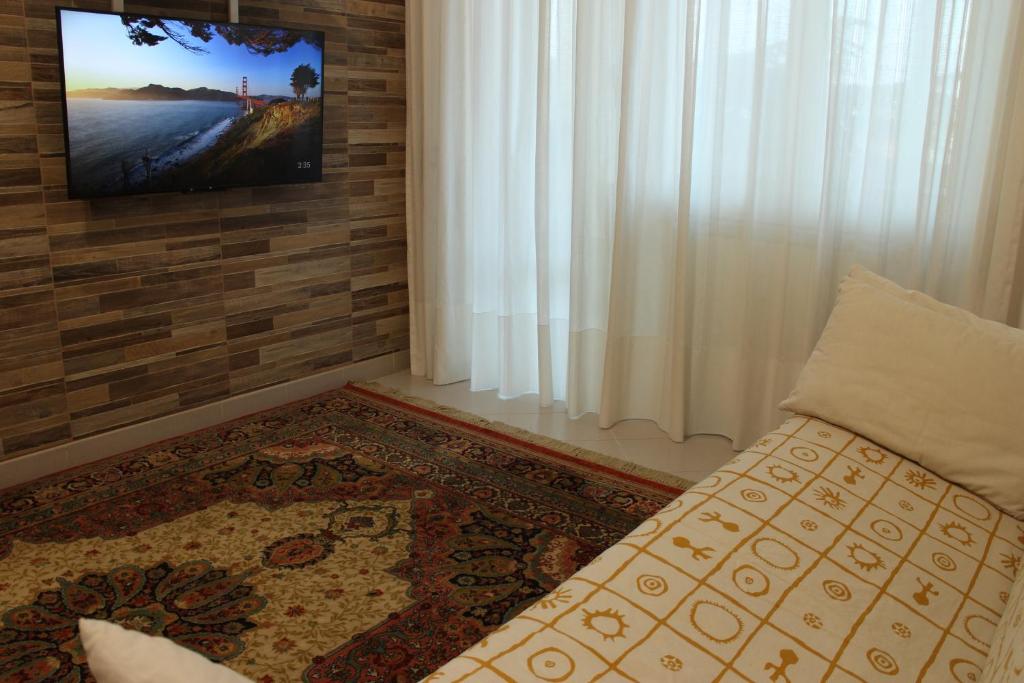 uma sala de estar com uma televisão na parede em VI Floor Apartment em Roma