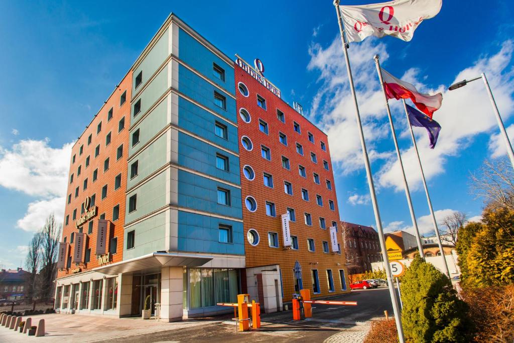 un edificio con dos banderas delante en Qubus Hotel Gliwice, en Gliwice