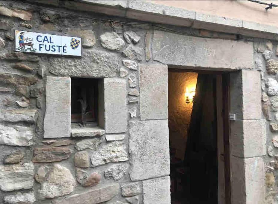 un edificio de piedra con un cartel que dice "fusibles" en Cal Fusté de Peramola, en Peramola