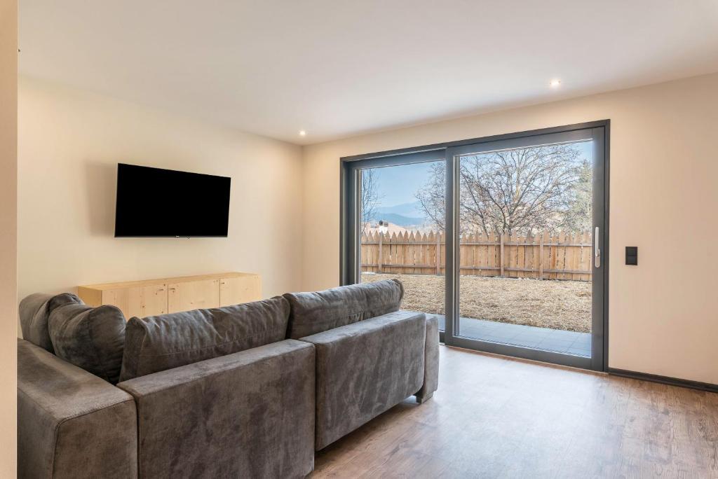 ein Wohnzimmer mit einem Sofa und einem TV in der Unterkunft Villa Lara Föhre in Kastelruth