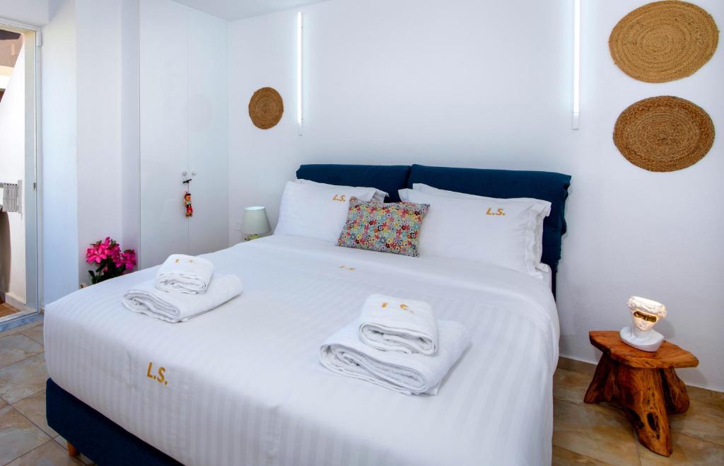 a bedroom with a white bed with towels on it at Lucky Suites in Rethymno Town