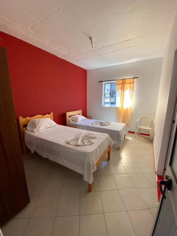 a room with two beds and a red wall at Casa Ze & sonia in Portela