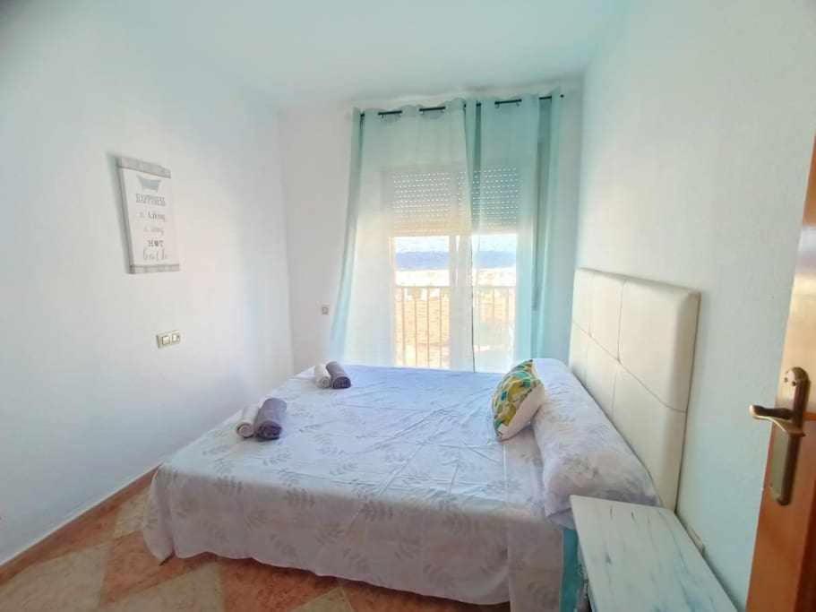 a bedroom with a large bed with a window at Apartamento Vista a la Isla in Carboneras
