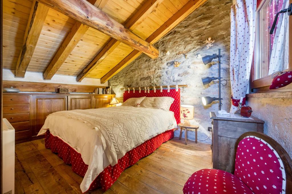 a bedroom with a red bed and a red chair at Arpy an in Morgex