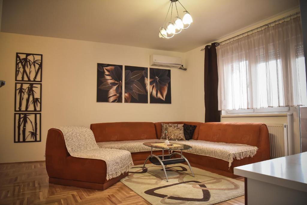 un soggiorno con un divano e un tavolo di Apartman Dado a Sombor