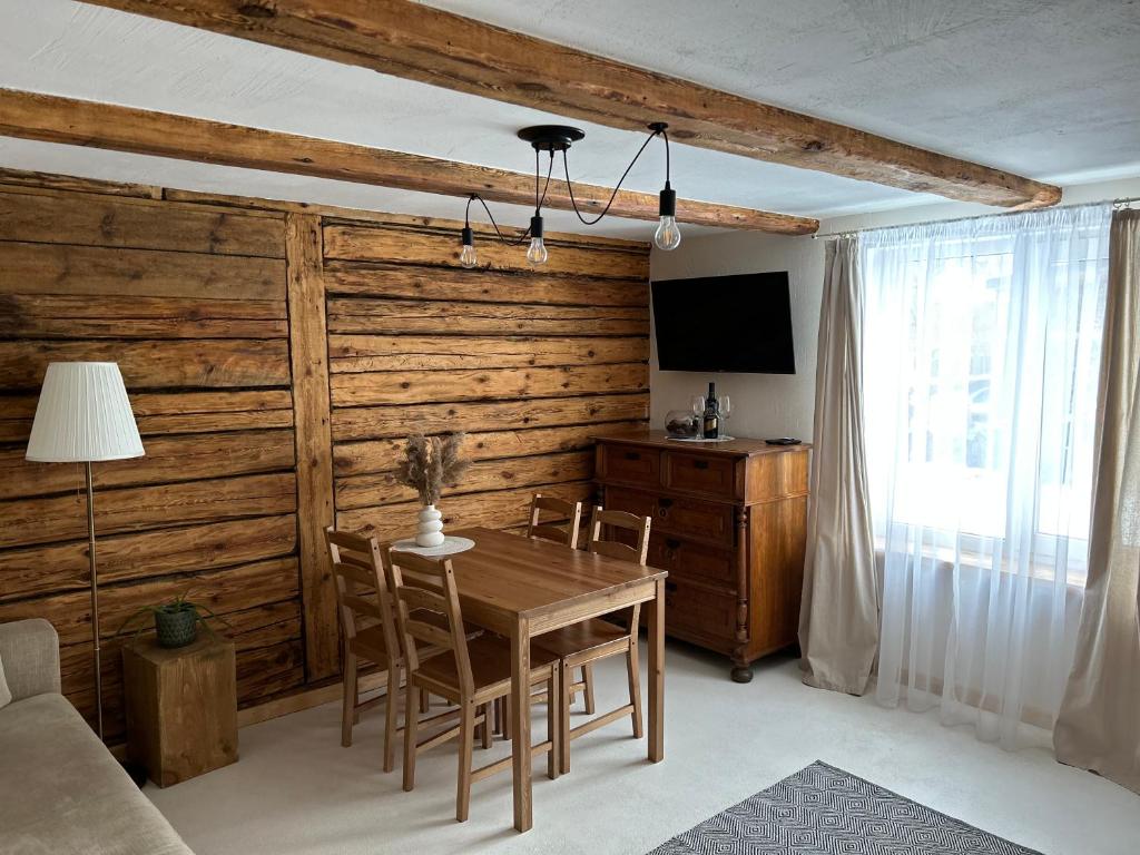 comedor con pared de madera, mesa y sillas en WILLOW, en Pāvilosta