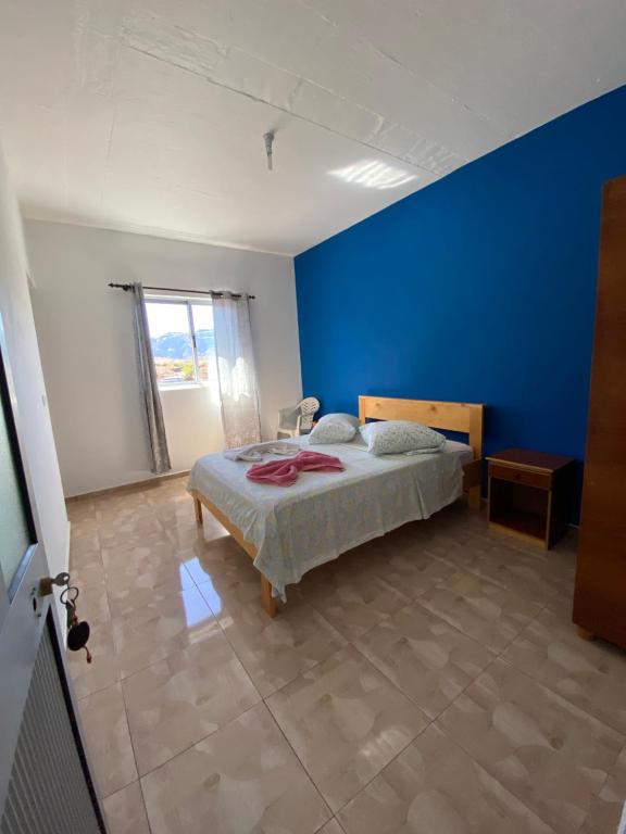 a bedroom with a bed with a blue wall at Casa Ze & sonia in Portela