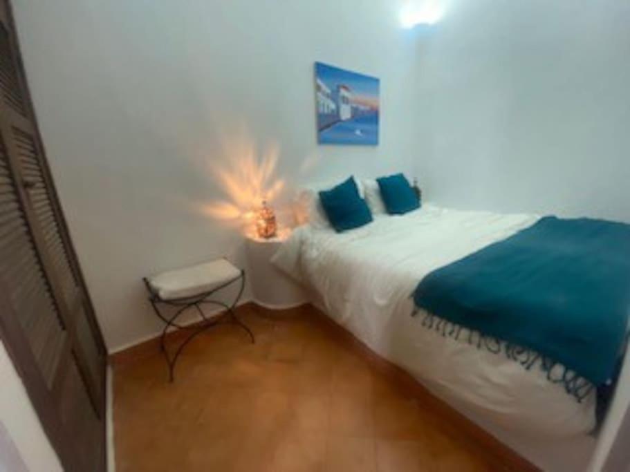 アシラにあるMedina houseのベッドルーム1室(青いシーツとスツール付きのベッド1台付)