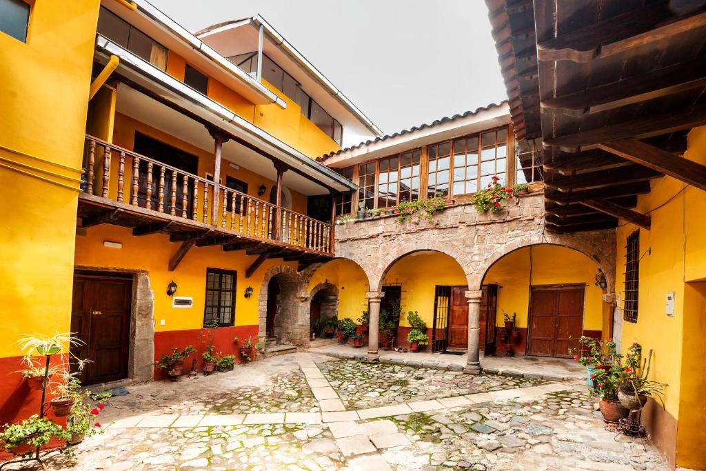 a courtyard of a building with yellow and red at Cusco'sHome 3 in Cusco