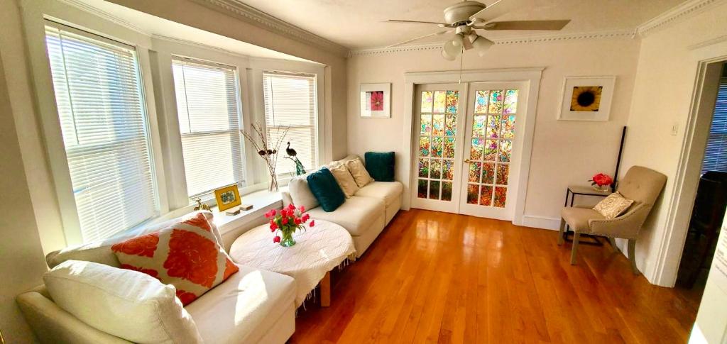 a living room with a couch and a ceiling fan at Near Train Station Gorgeous 3-Bedroom Apartment with Patios in Boston