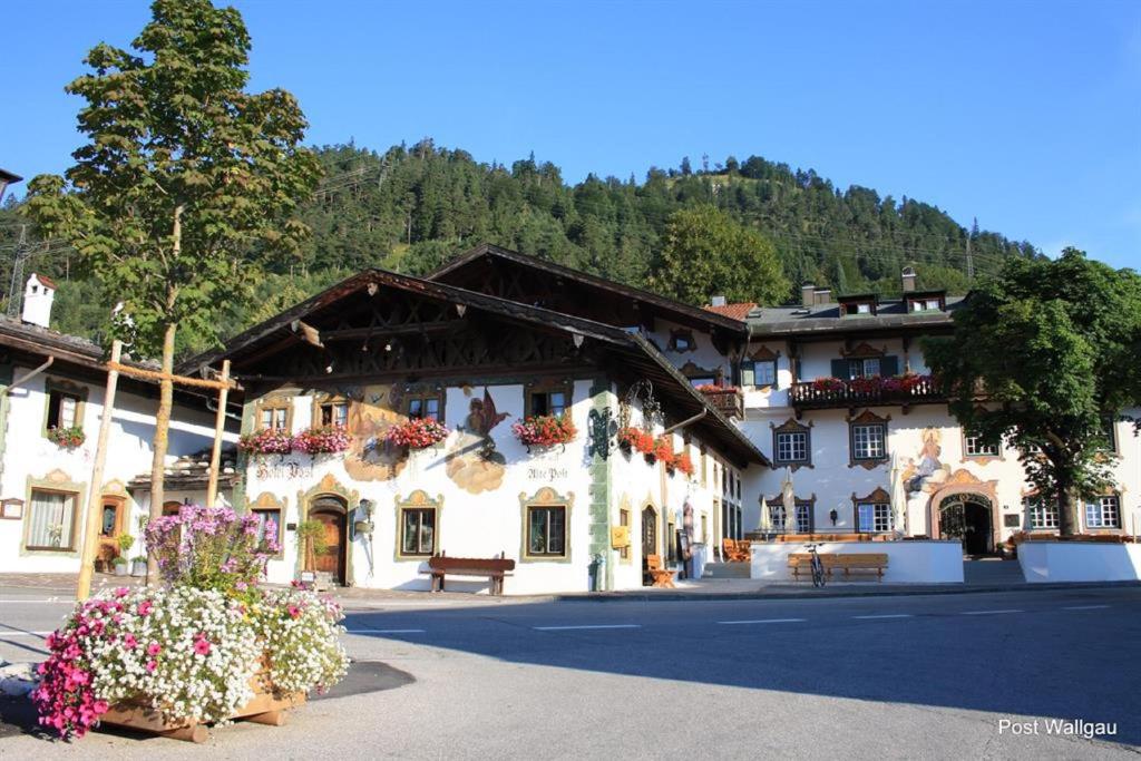 a large white building with flowers in front of it at Gasthof & Hotel Zur Post in Wallgau