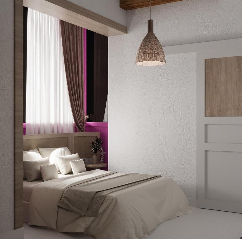 a white bedroom with a large bed with white pillows at Leo SereneS Hotel in Alacati