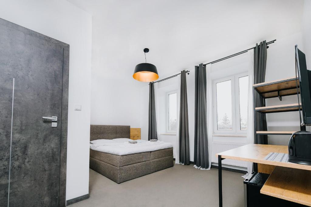 Zimmer mit einem Bett, einem Schreibtisch und einem Tisch in der Unterkunft Obiekt Noclegowy OCELOT II in Pruszków