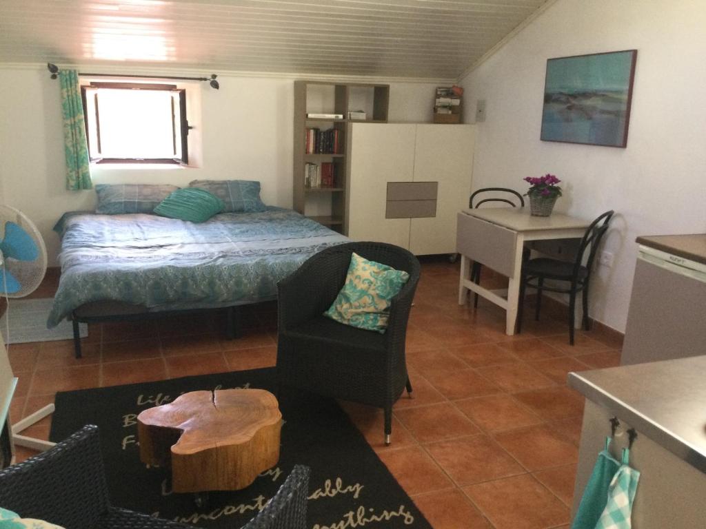 een kleine woonkamer met een bed en een tafel bij Flor da Ramila in Marvão