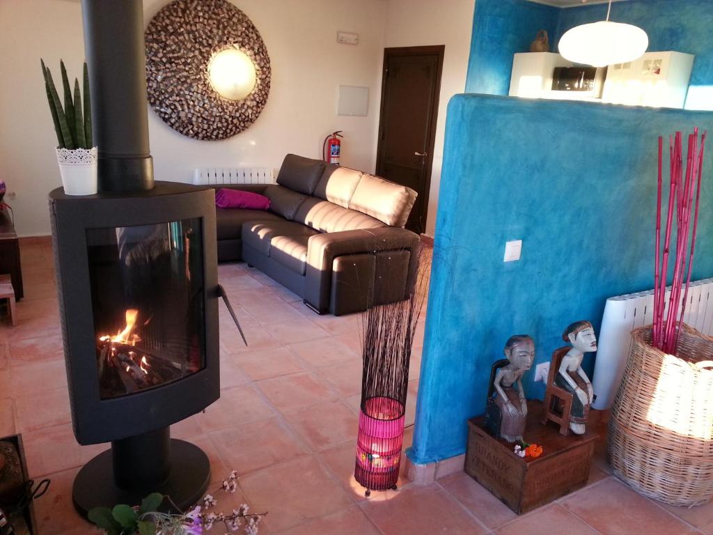 - un salon avec une cheminée et un canapé dans l'établissement Casas Rurales Planeta Chicote, à Zafra de Záncara