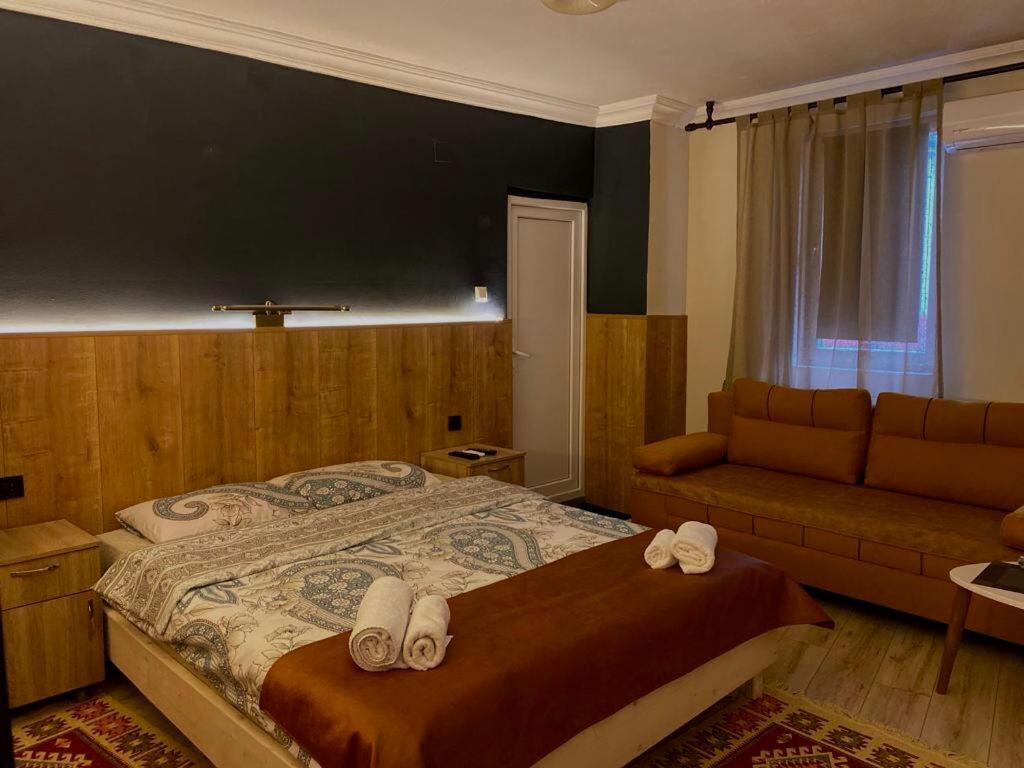 1 dormitorio con 1 cama grande y 1 sofá en Hotel Lido en Pristina