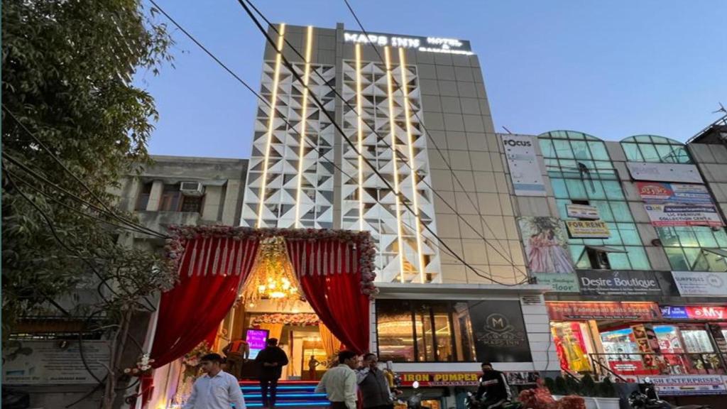 a building with people walking in front of it at Maps Inn in Ghaziabad