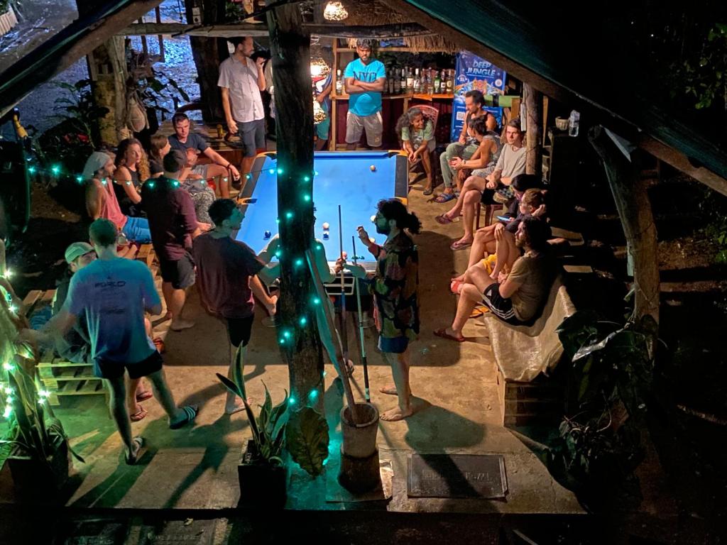 a crowd of people in a room with a projection screen at Tree house Hostel Sigiriya in Sigiriya