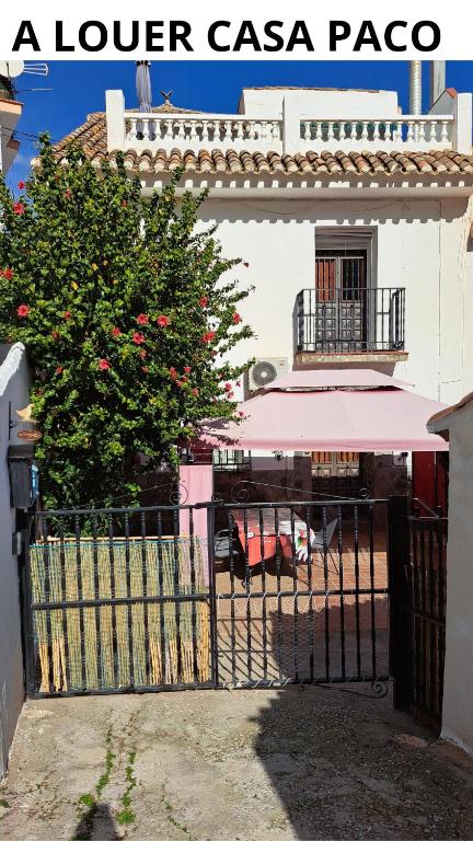 a gate to a lower casaazaaza with a tree and a building at CASA PACO - Maison Andalousie in Cútar