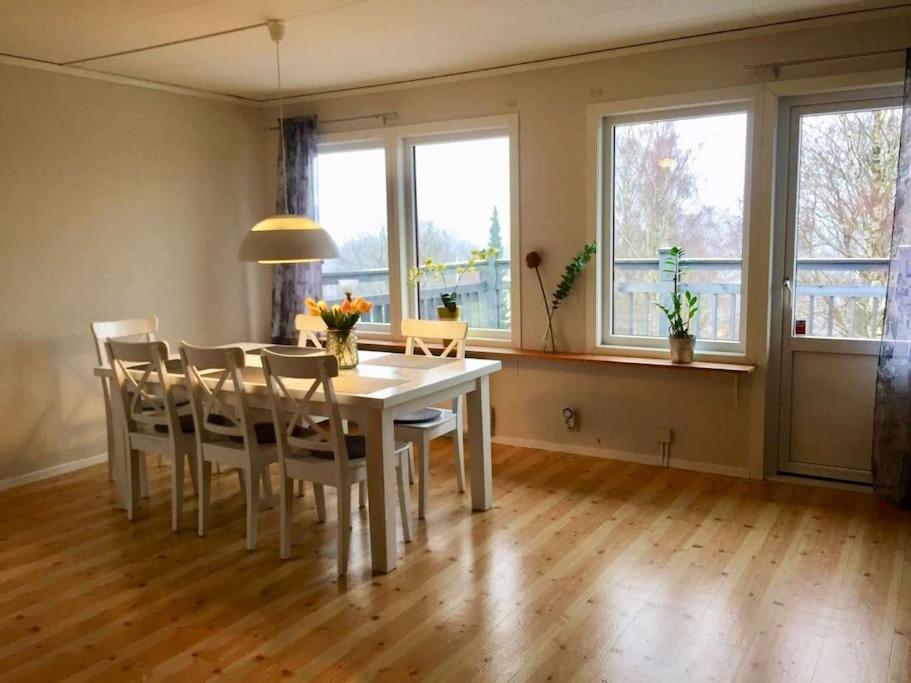 uma sala de jantar com mesa, cadeiras e janelas em Views of Isaberg and fitting two families! em Hestra