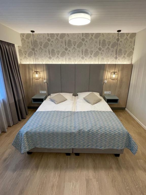 una camera da letto con un grande letto con due comodini di Hotel Strandhus a Cuxhaven