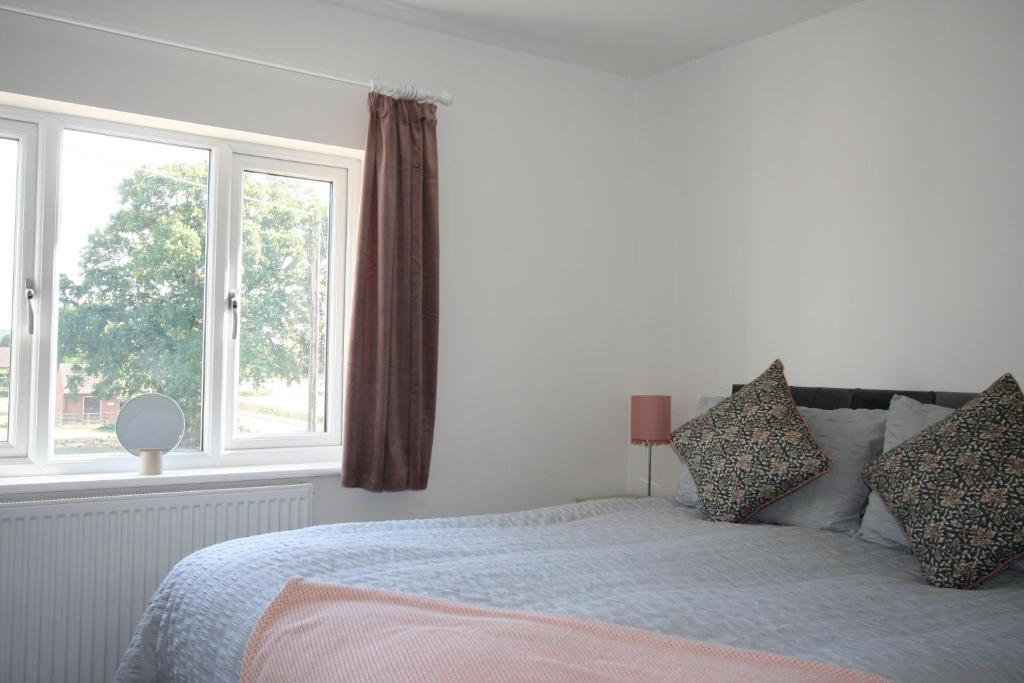 a bedroom with a bed and two windows at The Lodgings 3 Bed Cottage suitable for families breaks, working away Lincoln in Laneham