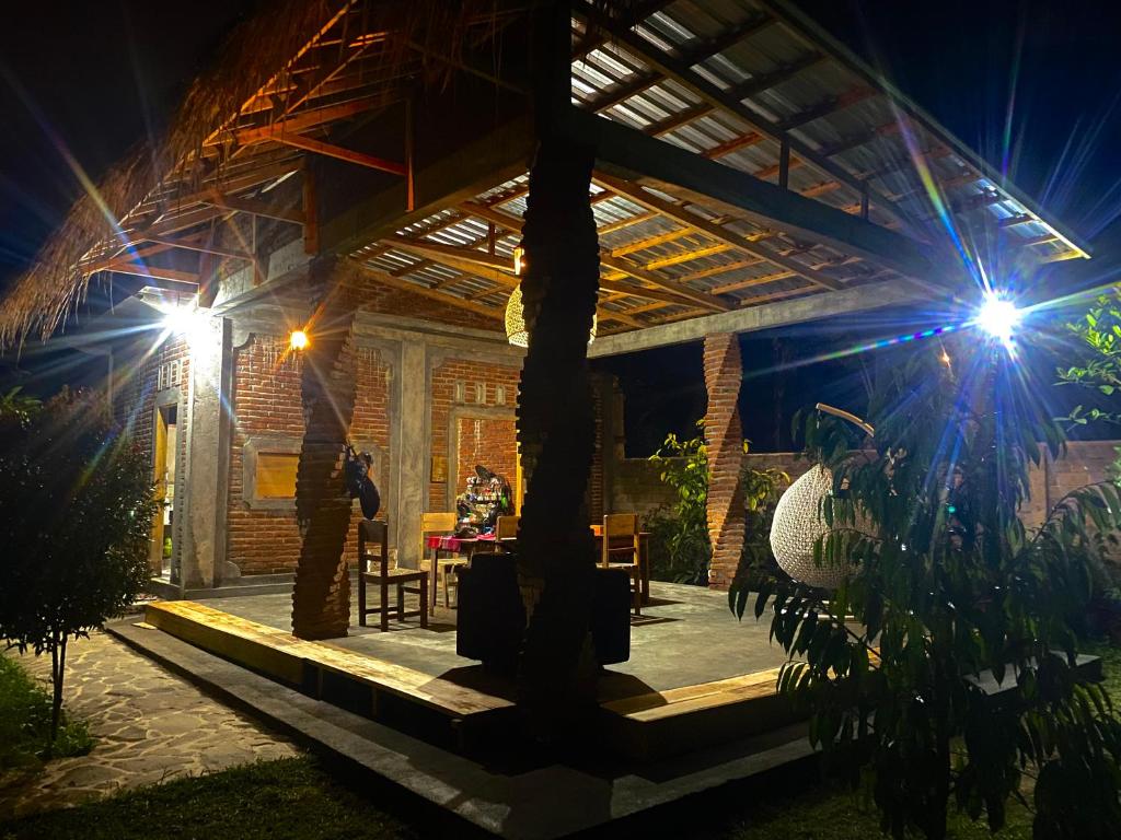 a house with a wooden roof at night at Al Sasaki in Tetebatu