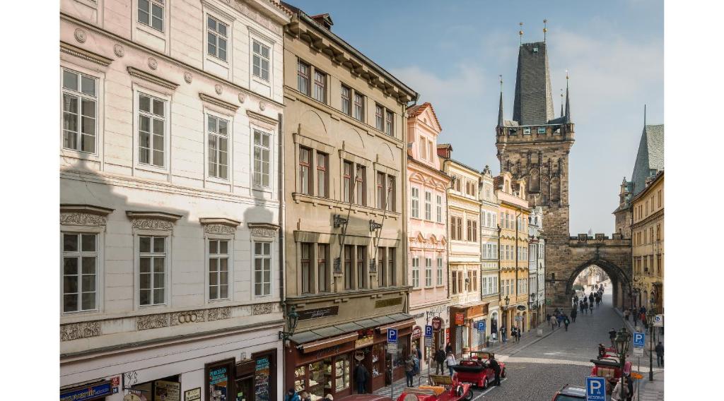 ulica miejska z budynkami i wieżą zegarową w obiekcie Mostecká 12 Residence w Pradze
